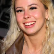 Hailey Welch smiling at a public event in 2025. The viral "Hawk Tuah Girl" has built a net worth of $500,000 through merchandise, appearances, and media ventures.