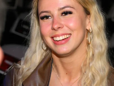 Hailey Welch smiling at a public event in 2025. The viral "Hawk Tuah Girl" has built a net worth of $500,000 through merchandise, appearances, and media ventures.