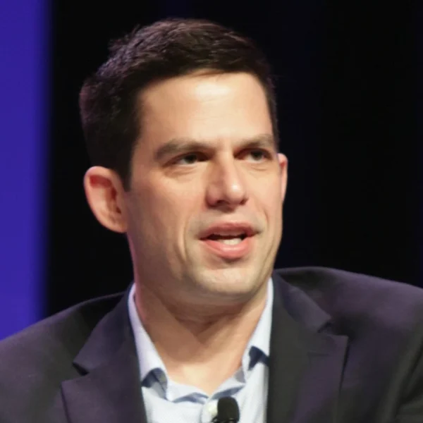 Jeffrey Marty speaking at a public event in a dark suit, representing his legal and media career.