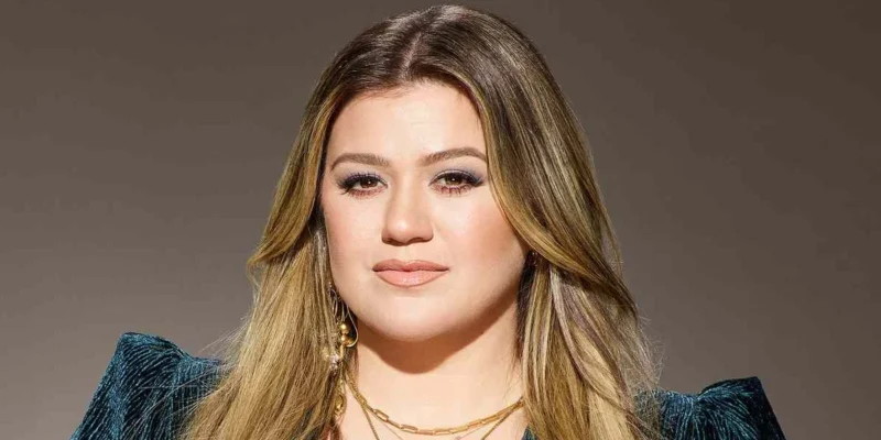Kelly Clarkson showcasing her confident style with blonde highlights and teal blazer - the multi-platform entertainment mogul continues to redefine celebrity success in 2025