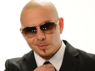 "Pitbull Net Worth 2025: Armando Christian Pérez in a sharp suit, smiling confidently with Miami skyline backdrop."