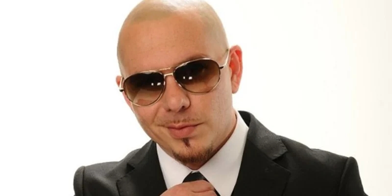 "Pitbull Net Worth 2025: Armando Christian Pérez in a sharp suit, smiling confidently with Miami skyline backdrop."