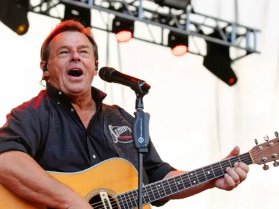 Sammy Kershaw performing live with acoustic guitar at outdoor country music concert stage