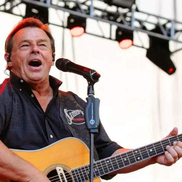 Sammy Kershaw performing live with acoustic guitar at outdoor country music concert stage