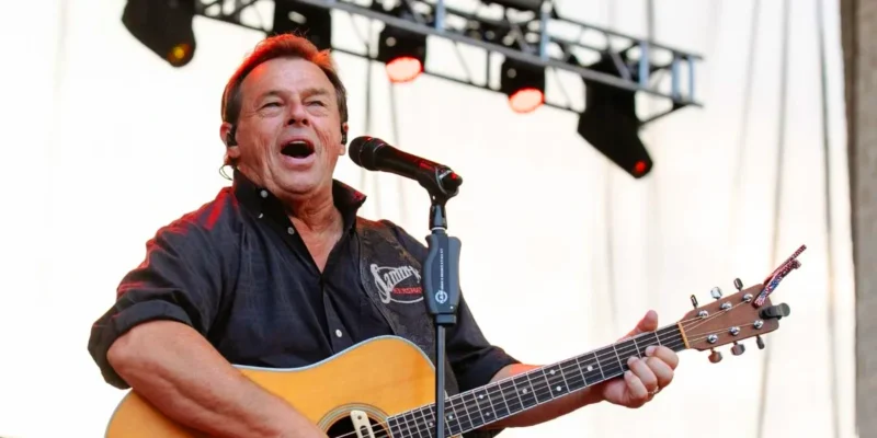 Sammy Kershaw performing live with acoustic guitar at outdoor country music concert stage