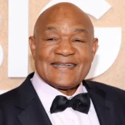 George Foreman smiling at a public event, representing his success story in boxing and business featured in our article on George Foreman.