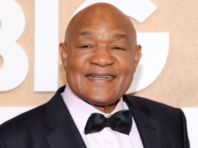 George Foreman smiling at a public event, representing his success story in boxing and business featured in our article on George Foreman.