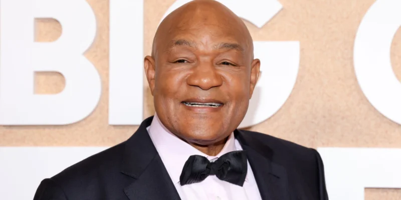 George Foreman smiling at a public event, representing his success story in boxing and business featured in our article on George Foreman.
