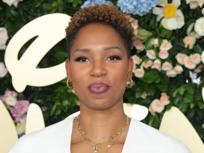 Monica McNutt, ESPN basketball analyst and sports broadcaster, showcasing her signature style at a media event against a floral backdrop
