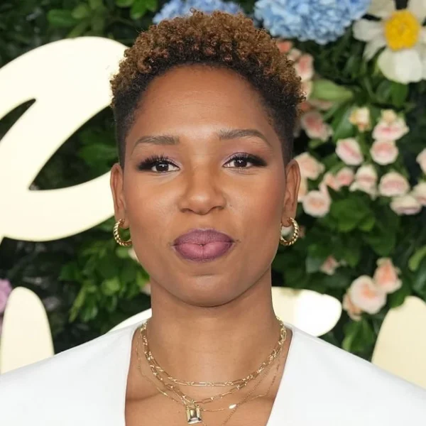 Monica McNutt, ESPN basketball analyst and sports broadcaster, showcasing her signature style at a media event against a floral backdrop