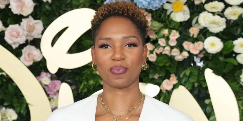 Monica McNutt, ESPN basketball analyst and sports broadcaster, showcasing her signature style at a media event against a floral backdrop