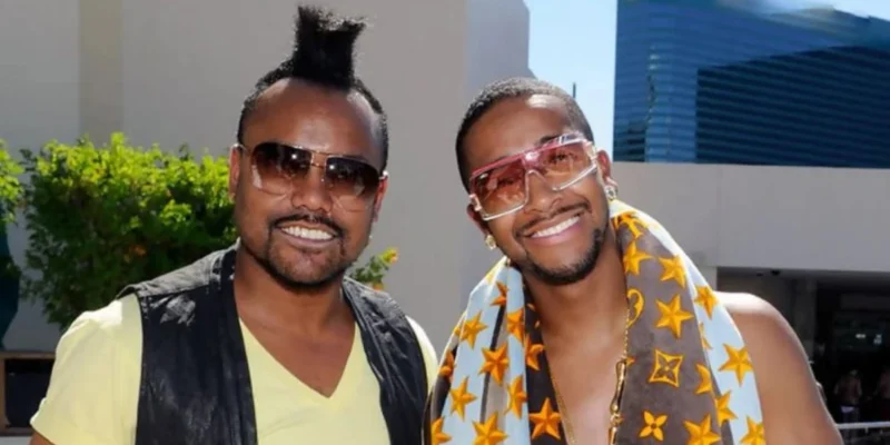 Ukil Grandberry and associate wearing fashionable clothing and sunglasses in professional photo shoot setting.
