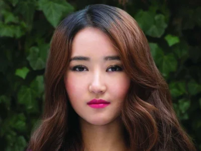 Yeonmi Park Net Worth: Yeonmi Park smiling confidently outdoors, symbolizing her inspiring journey and financial achievements.