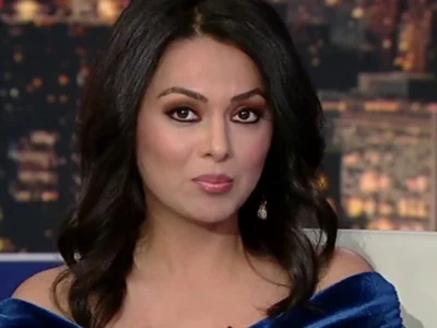 Aisha Hosny on set in a blue dress, confidently presenting live news, reflecting her growing influence in 2025 media.