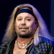 Vince Neil performing live on stage with signature blonde hair and leather jacket, showcasing the Mötley Crüe frontman's iconic rock star presence before his 2025 health challenges