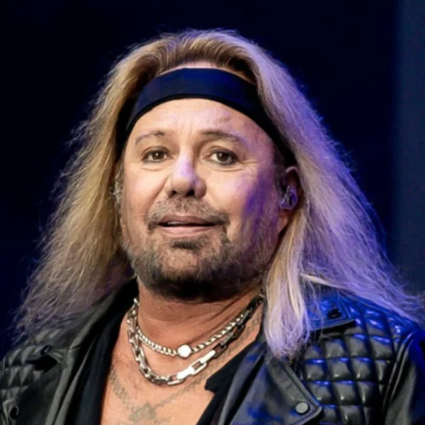 Vince Neil performing live on stage with signature blonde hair and leather jacket, showcasing the Mötley Crüe frontman's iconic rock star presence before his 2025 health challenges