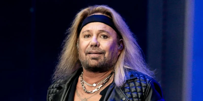 Vince Neil performing live on stage with signature blonde hair and leather jacket, showcasing the Mötley Crüe frontman's iconic rock star presence before his 2025 health challenges